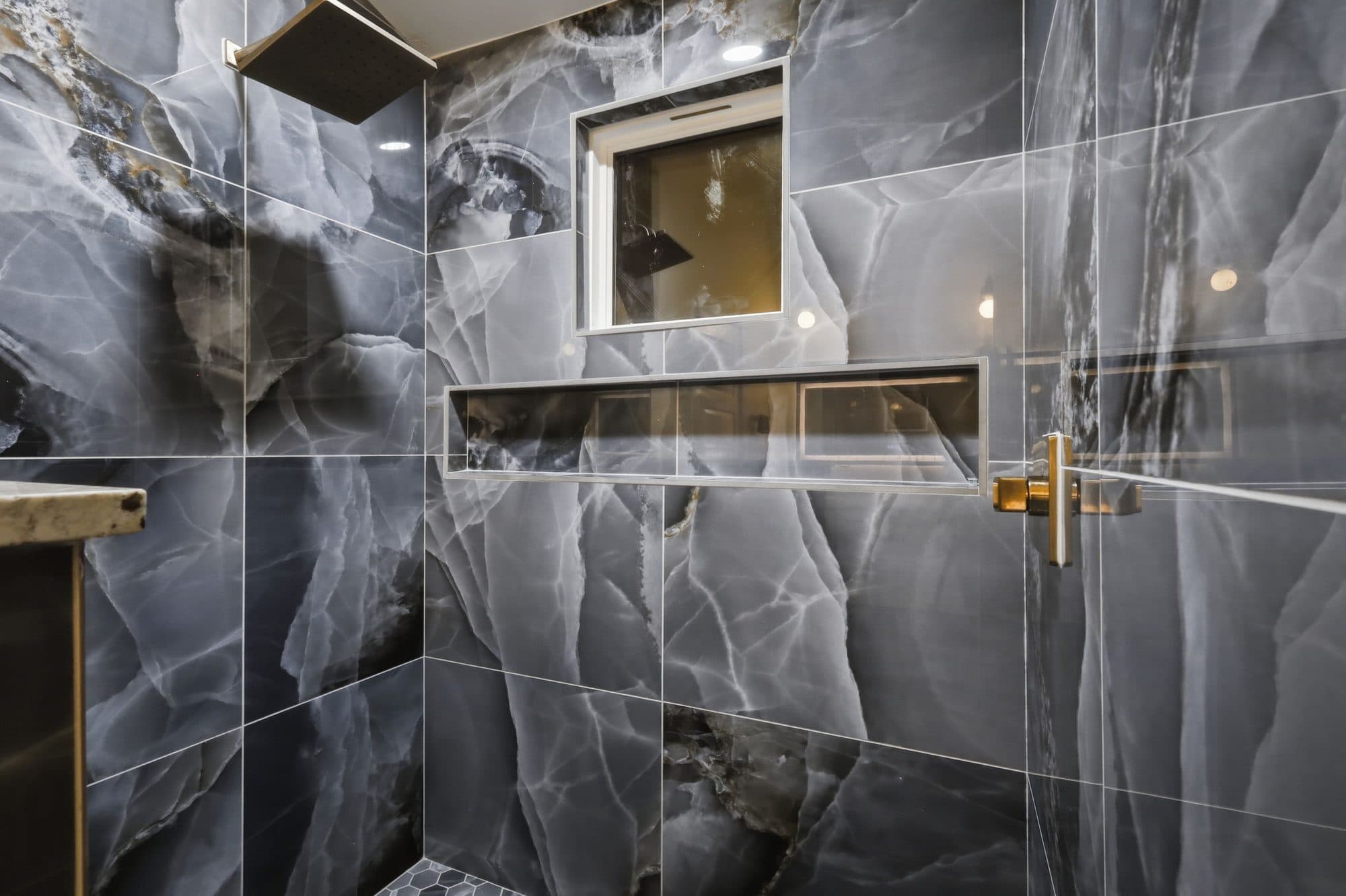 Walk-in shower with blue stone tile and brass fixtures at 917 Burnet Street