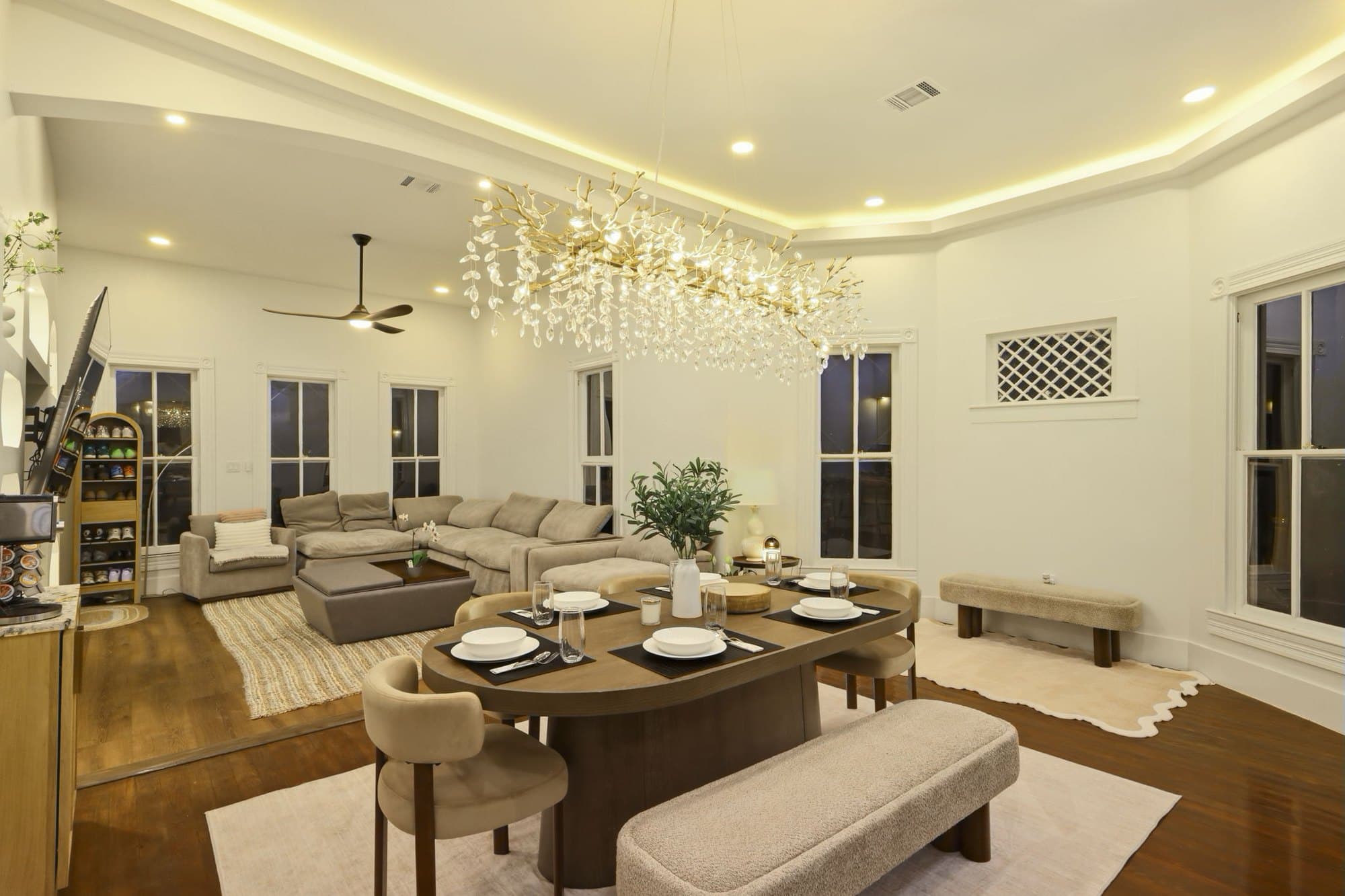 Living and dining areas open to each other under a sculptural chandelier