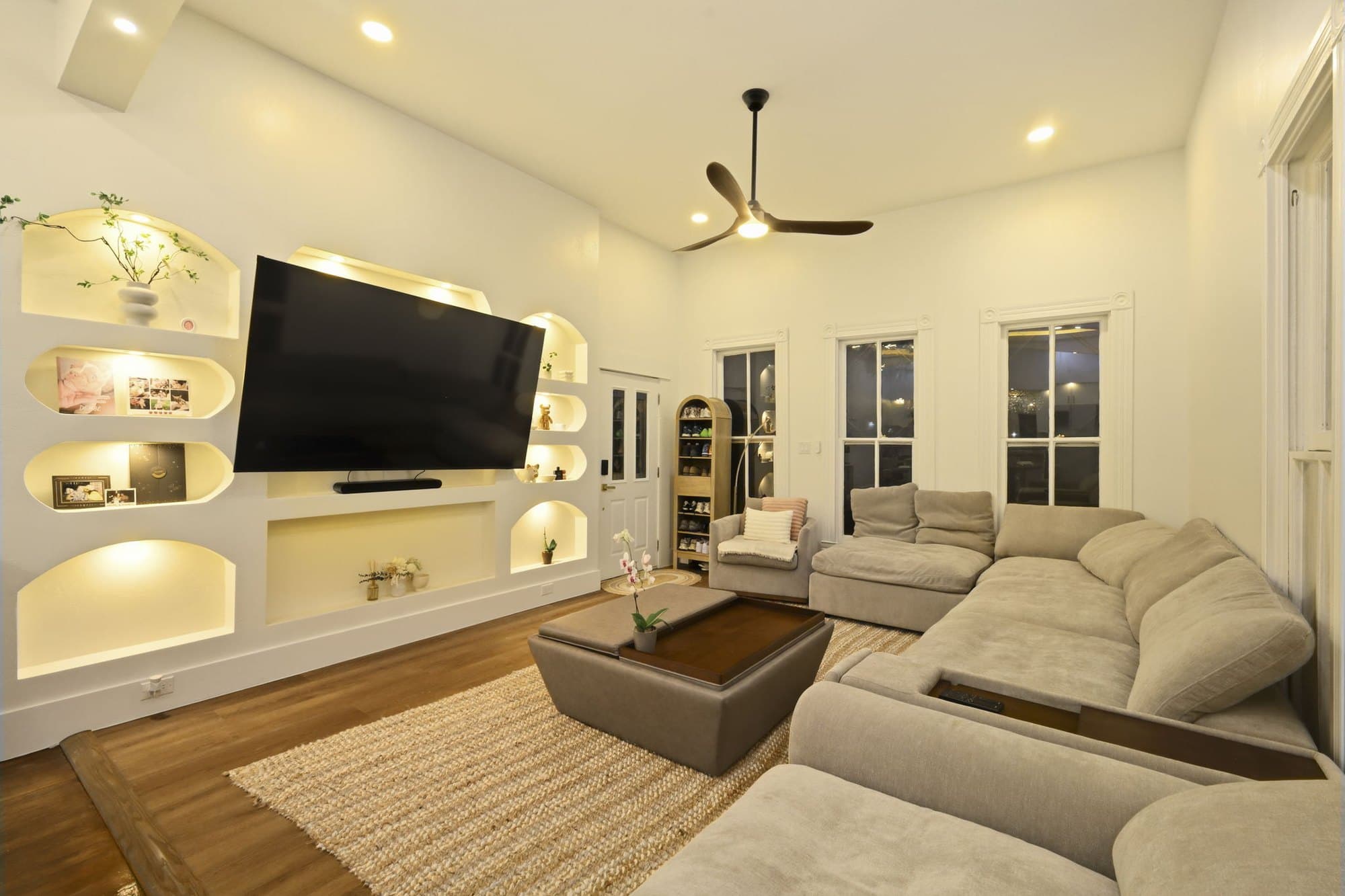 Open living room with a built-in media wall and lit display niches