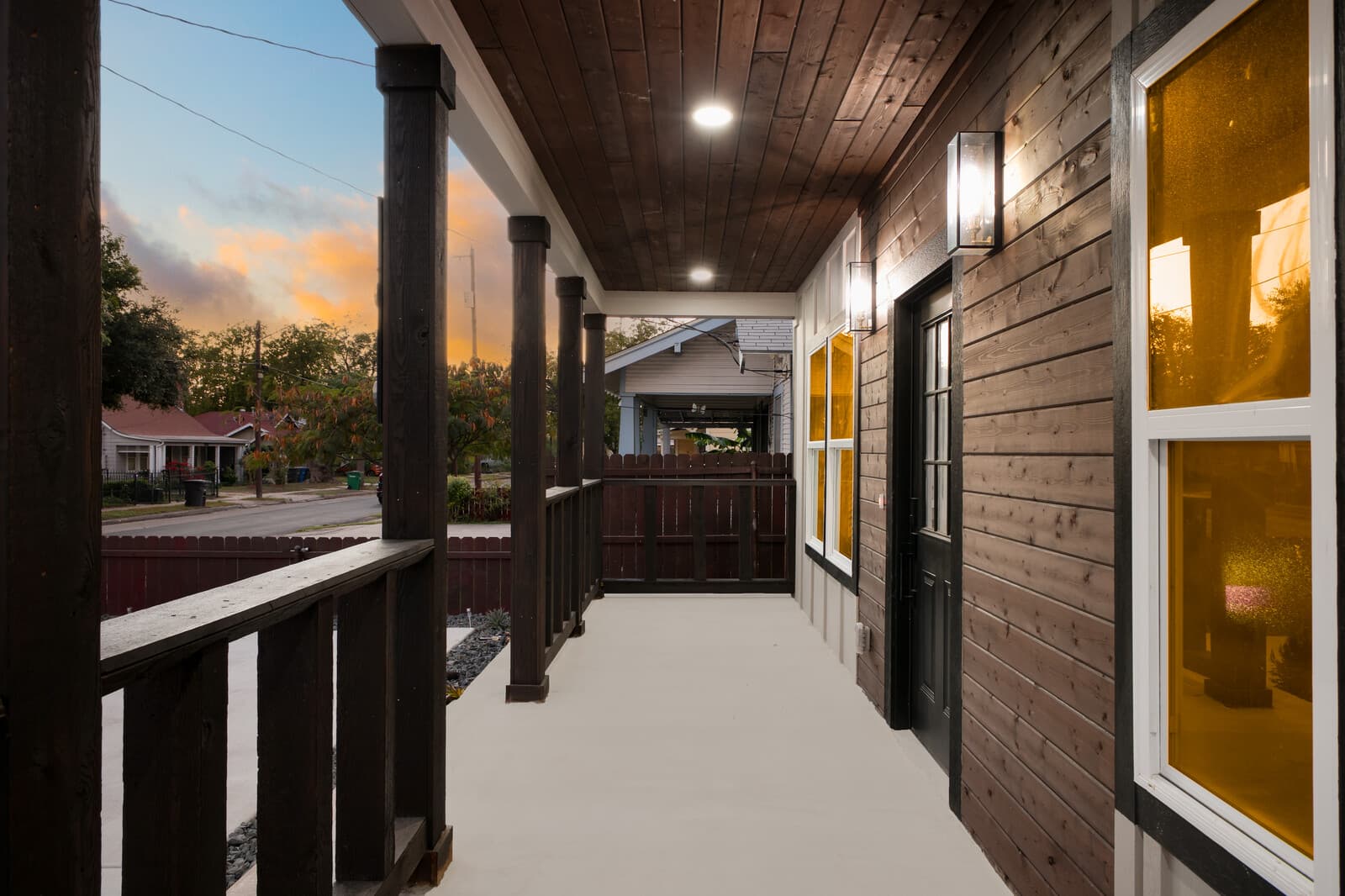 Covered side porch looking out toward the street at dusk