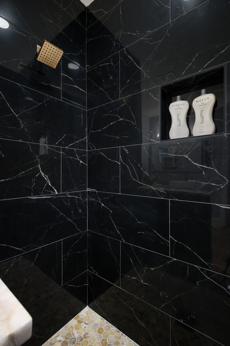 Black marble shower surround with a recessed niche