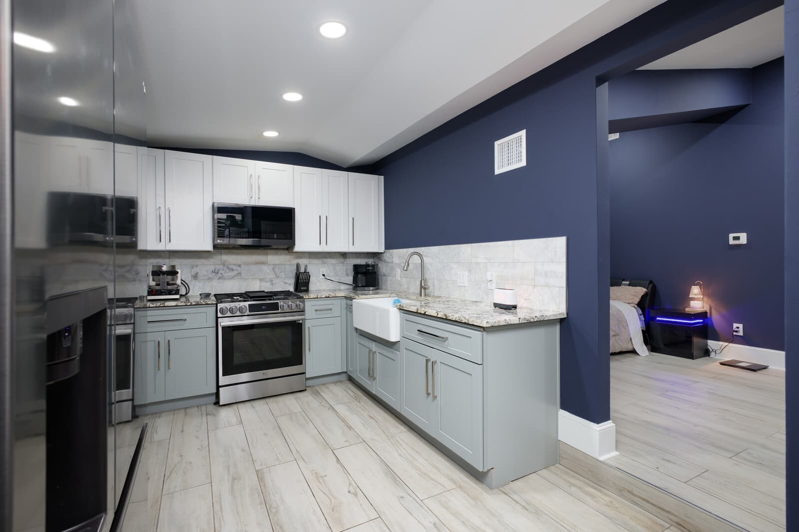 ADU kitchen with white cabinetry, stainless range and a navy accent wall
